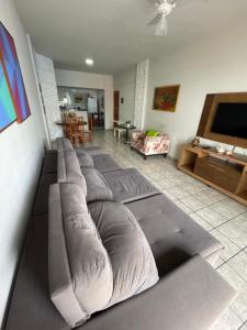 a living room with a bunch of pillows on a couch at Apartamento Praia do Morro com Churrasqueira, Cozinha Gourmet e Wifi in Guarapari