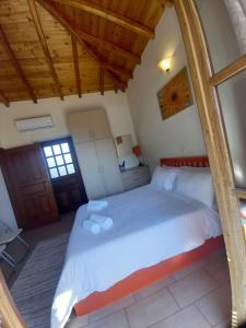 sypialnia z dużym łóżkiem i drewnianym sufitem w obiekcie Karantonis House w mieście Leonidion