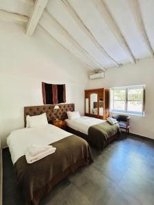 a hotel room with two beds and a window at Postales Hotel Boutique Valle De Uco in Colonia Las Rosas