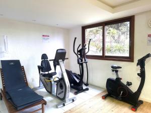 a gym with treadmills and exercise bikes in a room at Lindo apto no Condomínio Enseada Praia do Forte in Mata de Sao Joao