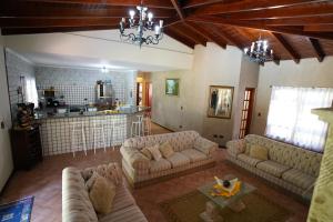 ein großes Wohnzimmer mit Sofas und einer Küche in der Unterkunft Sitio Recanto Feliz na Estrada do Vinho km 4,5 - Sao Roque in São Roque