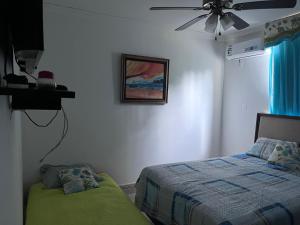 um quarto com uma cama e uma ventoinha de tecto em MM VILLA na Cidade do Panamá