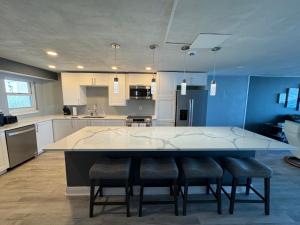 a large kitchen with a large white table and chairs at DIRECT OCEANFRONT NO-DRIVE BEACH CONDO in Daytona Beach