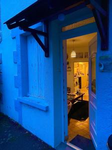 uma casa azul com uma porta que leva a uma cozinha em Maison indépendante em Noyant-dʼAllier