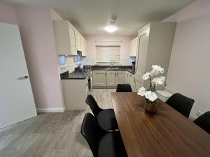 a dining room with a table and chairs and a kitchen at ORCHID S&N House in Bristol