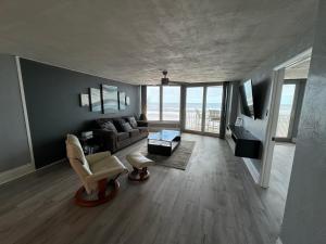 a living room with a couch and a chair at DIRECT OCEANFRONT NO-DRIVE BEACH CONDO in Daytona Beach