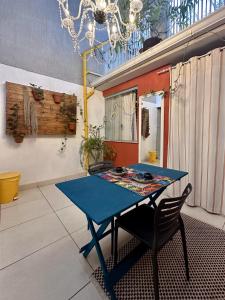 a blue table and a chair in a room at CASA LUMEN Home Hostel in Núcleo Bandeirante