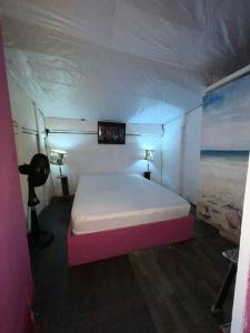 a bedroom with a white bed with a pink frame at Tours Mandala Beach in Baru