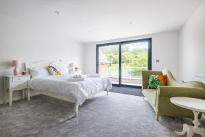 a white bedroom with a bed and a chair at H2-Roof Top-3 Bedrooms-2BA-Free Parking-Sleeps 6 