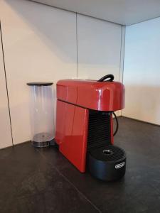 a red coffee maker sitting on the floor at appartement cosy in Tafers