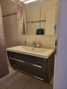 uma casa de banho com um lavatório e um espelho em appartement cosy em Tafers