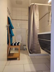 uma casa de banho com uma banheira, um WC e um chuveiro em appartement cosy em Tafers