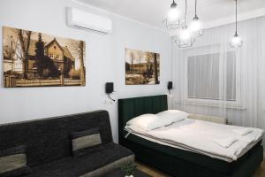 Apartamenty Różane في Laski: غرفة نوم فيها سرير واريكة