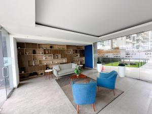 a living room with blue chairs and a couch at Nuevo departamento con vista al mar y piscina-Pool One in Lima
