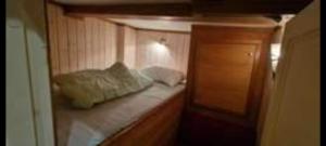 mały pokój z łóżkiem i drewnianą szafką w obiekcie Tunfisk II w mieście Vardø