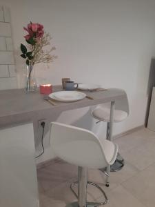 a table with two chairs and a vase with flowers at Studio Violet blisko rynku in Kalisz