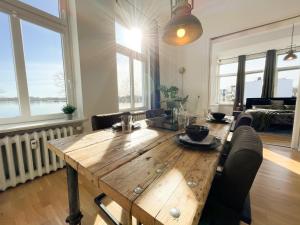 a wooden table in a living room with windows at Altbauwohnung mit Schleiblick - Erster Stock in Schleswig