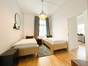 a bedroom with two beds and a mirror at Altbauwohnung mit Schleiblick - Erster Stock in Schleswig