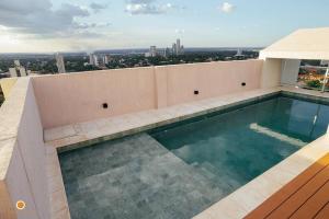 uma piscina no telhado de um prédio em Cookandmusicapartments Forvm Molas Lopez em Assunção
