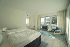 1 dormitorio con 1 cama, mesa y sillas en Ferienwohnung Strandhüpfer - direkt am Meer en Eckernförde