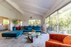 uma sala de estar com sofás azuis e uma mesa em Stunning Hollywood Midcentury Modern-Views-Best Location! em Los Angeles