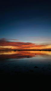 a sunset on a beach with the sky at Cosy Coastal 2-Bedroom Cottage with Hot Tub and Log Burner in West Mersea