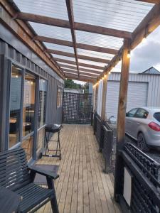 a patio with two chairs and a pergola at The Snug - Rural Hideaway in Invercargill