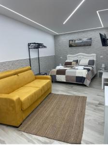 ein Wohnzimmer mit 2 Betten und einem gelben Sofa in der Unterkunft Metro Stazione-Museo 500 m-Appartamento Centrale ed Elegante Dimora De Curtis in Neapel