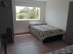 a bedroom with a bed and a window at Lindo apartamento en Guatapé in Guatapé