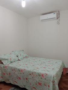- une chambre avec un lit et une couette à fleurs dans l'établissement Casa jmn, à Logradouro