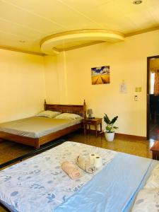 - une chambre avec 2 lits et une table avec des serviettes dans l'établissement Chateau La Princesa with cozy terrace, à Puerto Princesa
