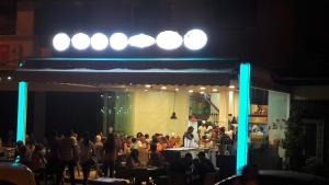 una multitud de personas sentadas en mesas delante de un escenario en Silia Appartements, en Temara