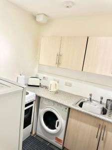 cocina con lavadora y fregadero en C&E Apartment, en Edimburgo