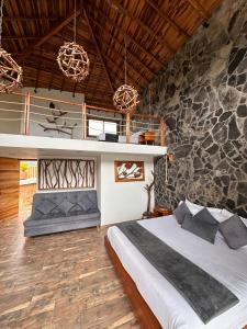 a bedroom with a bed and a stone wall at Hotel Campestre Palmas del Zamorano in San Gil