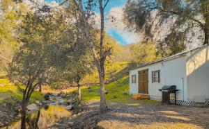 a white cabin with a tree in front of it at Genas's Sierra Inn & Restaurant in Dunlap