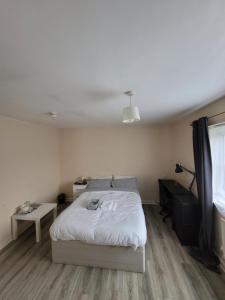 um quarto com uma cama branca e uma janela em Firedrake Croft em Parkside