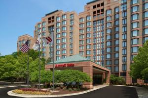 ein Hotel mit zwei amerikanischen Flaggen vor einem Gebäude in der Unterkunft Chicago Marriott Suites O'Hare in Rosemont