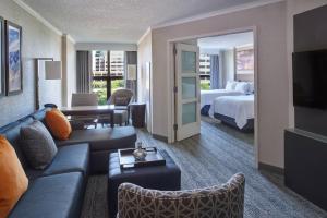 a hotel room with a couch and a bed at Chicago Marriott Suites O'Hare in Rosemont