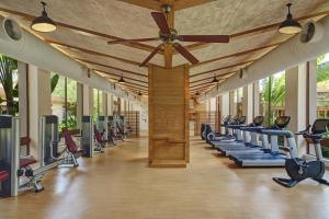 a gym with a row of treadmills and machines at Sheraton Shenzhou Peninsula Resort in Wanning