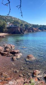 un cuerpo de agua con rocas en el agua en Studio Cap Esterel By Sara, en Saint-Raphaël