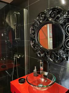 a bathroom with a red sink and a mirror at Fontainha House & SPA in Caldelas