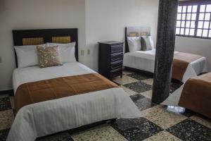 a hotel room with two beds and a mirror at Múcara hotel in Veracruz