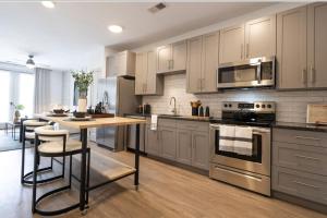 a kitchen with stainless steel appliances and a wooden table at Charming 1BR 1BA Apartment Near Downtown Cincinnati in Cincinnati