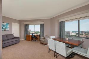 a living room with a table and chairs and a desk at The Westin Dallas Park Central in Dallas +24 photos