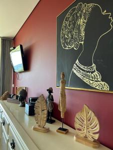 a room with a wall with a painting and some figurines at Fontainha House & SPA in Caldelas