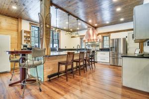 an open kitchen with wooden floors and wooden ceilings at Maine Home with Private Hot Tub and ATV Trail Access! 