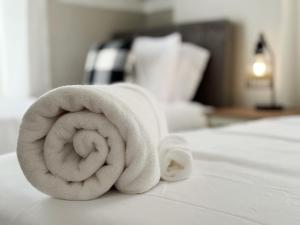 toalla blanca enrollada en una cama en Cherry Street Retreat en Evansville