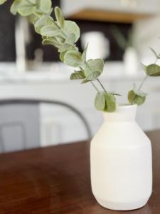 un jarrón blanco con una planta en una mesa en Cherry Street Retreat en Evansville