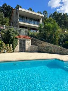 une maison avec une piscine en face d'une maison dans l'établissement Fontainha House & SPA, à Caldelas