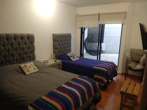 1 Schlafzimmer mit 2 Betten, einem Stuhl und einem Fenster in der Unterkunft BRAND NEW APARTMENT NEAR DOWNTOWN COYOACÁN! in Mexiko-Stadt